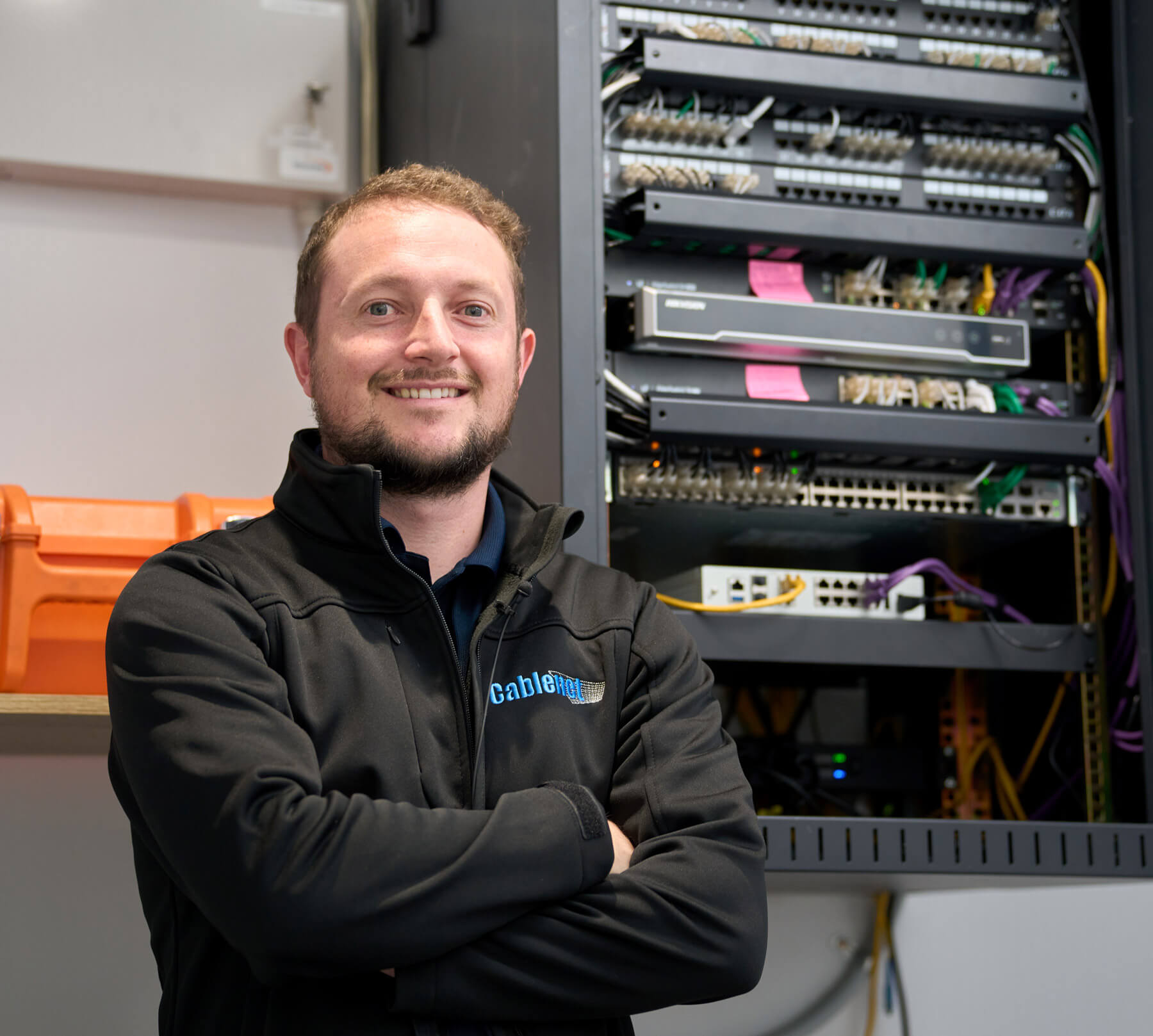 Cablenet Employee standing next to a server terminal